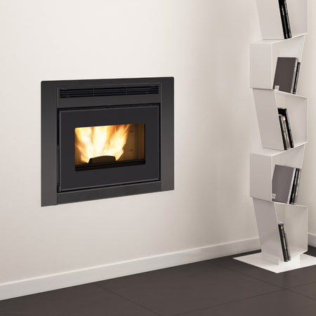 Ambientebild: Extraflame wasserfuehrender Pellet-Kamineinsatz COMFORT IDRO L80.16 in weisser Wand eingebaut, Flamme sichtbar, Regal daneben | Klimaworld.com
