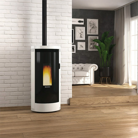 Ambientebild: Extraflame beluefteter Pelletofen DEBBY EVO 9,0 kW in Weiss mit Glasfront, Flamme vor Ziegelwand modern | Klimaworld.com