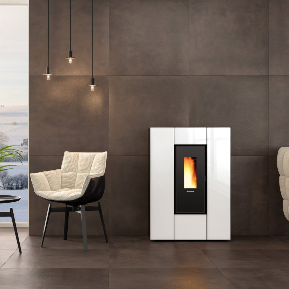 Ambientebild: schlanker Extraflame kanalisierter Pelletofen MARILENA PLUS CRYSTAL 5.0.16 in Weiss-Schwarzer Glasfront vor dunkler Wand im Wohnraum mit Flamme | Klimaworld.com