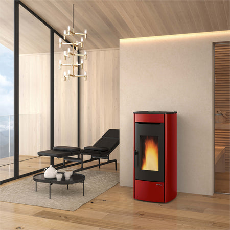 Ambientebild: Extraflame Pelletofen MARINA IDRO H13 in Rot mit schwarzer Front und Sichtfenster, Flamme brennt, moderner Wohnraum mit Holzdecke | Klimaworld.com