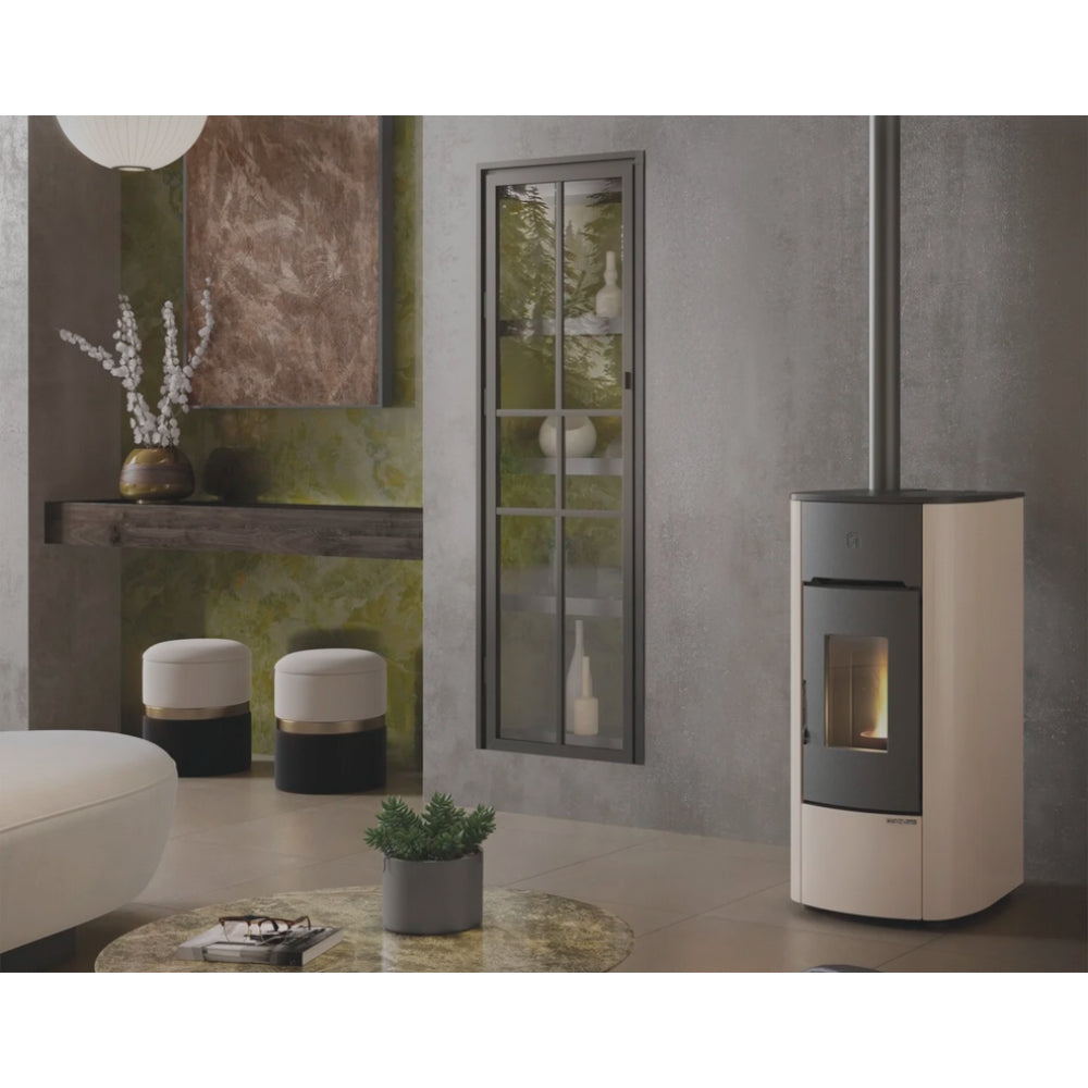 Ambientebild: Extraflame Pelletofen ANGELICA PLUS in Elfenbein, in modernem Wohnzimmer neben Fenster, Regal, Hocker und Tisch mit Pflanze | Klimaworld.com
