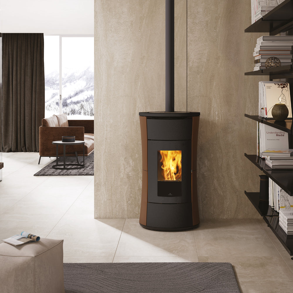 Sanduhrförmiger Pelletofen Cherie 9+ EVO Top mit bronze Verkleidung im winterlichen Wohnzimmer | Klimaworld.com