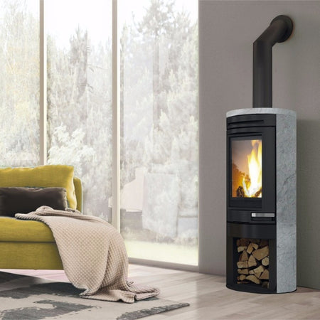 Edilkamin Kaminofen Tally Int mit Holzlagerfach und Flammenbild in winterlichem Ambiente, Natursteinverkleidung | klimaworld.com