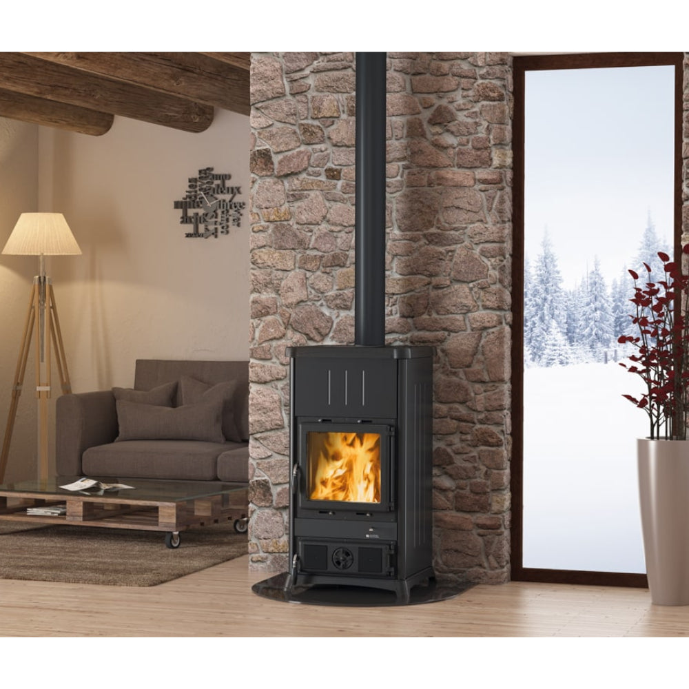 La Nordica Kaminofen FEDORA.16 STEEL in Schwarz mit Flammenbild Beispiel im winterlichen Wohnzimmer | Klimaworld.com