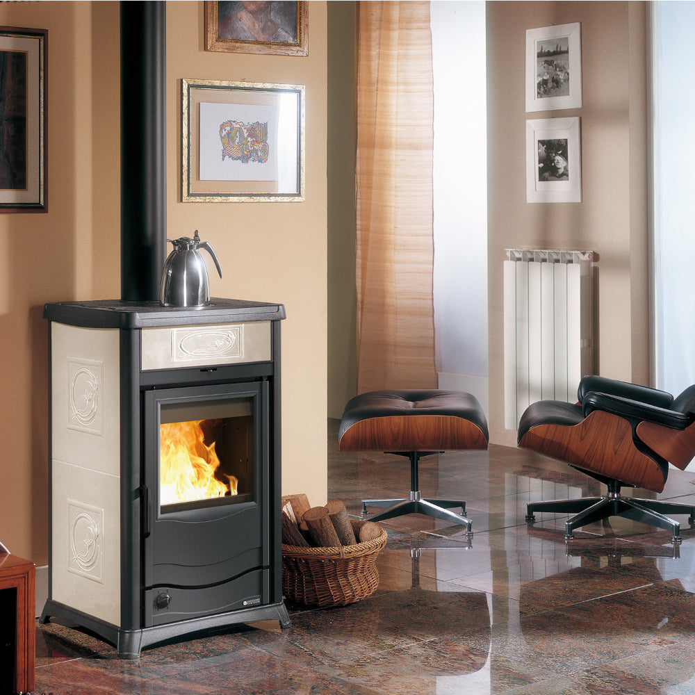 La Nordica Holzofen TERMOROSSELLA PLUS DSA.16 creme mit schwarzer Front, Flamme, Wohnzimmer mit Sessel, Bildern, Heizkoerper | Klimaworld.com