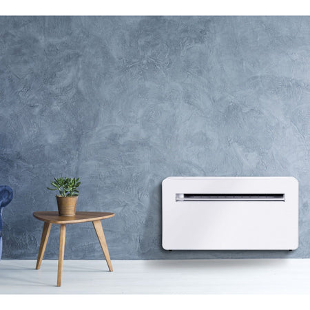 Ambientebild: MundoClima Monoblock Klimageraet MUSER-10-H12 (MC-CL20100), weisses Wandgeraet vor blauer Wand neben kleinem Holztisch mit Pflanze | Klimaworld.com
