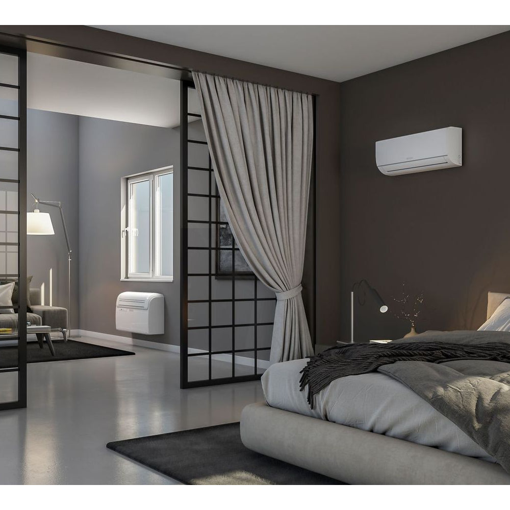 ambientebild: OLIMPIA SPLENDID Split Klimaanlage Unico Twin in zwei Wohnraeumen mit Bett, Fenster und grauem Vorhang | Klimaworld.com
