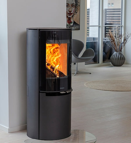 Aduro H4 Lux Hybridofen im Wohnzimmer stehend mit Funkenschutzplatte auf dem Boden und schönem Flammenspiel  | Klimaworld.com