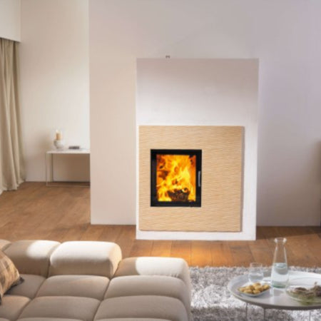 Kera Xtra 45 Kamineinsatz brennend, weisse Umrahmung, Wohnzimmer mit Sofa und Teppich, minimalistisch | klimaworld.com