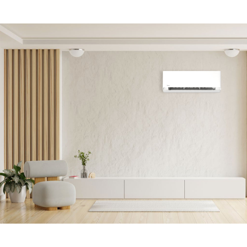 Ambientebild im Wohnzimmer mit installiertem MIDEA Breezeless Wandgeraet, minimalistische beigefarbene Einrichtung mit Sofa und Pflanzen | klimaworld.com