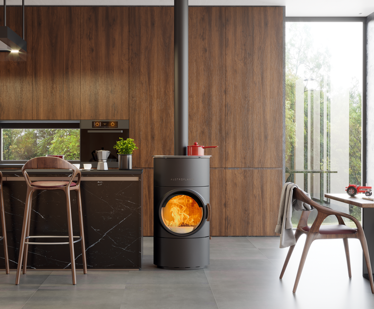 Schwarzer Austroflamm Kaminofen Clou Compact Cook mit Flammenbild im runden Sichtfenster in moderner Kueche | Klimaworld.com