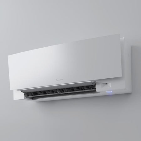 Daikin Emura Klimaanlagen-Wandgeraet in Weiss, Front leicht geoeffnet, sichtbarer Luftauslass und LED-Ring an der Unterseite | Klimaworld.com